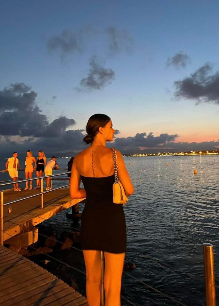 Décrire images : fille de dos face à la mer et coucher de soleil