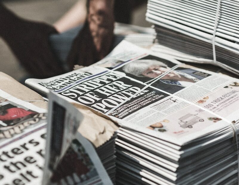 shallow focus photography of piles of newspapers